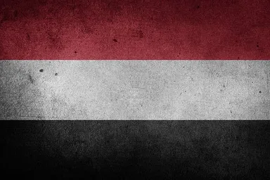 Grunge-textured flag of Yemen with horizontal red, white and black stripes.