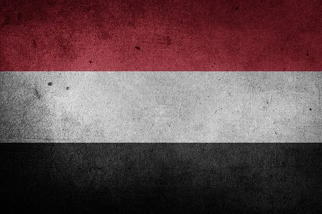 Grunge-textured flag of Yemen with horizontal red, white and black stripes.