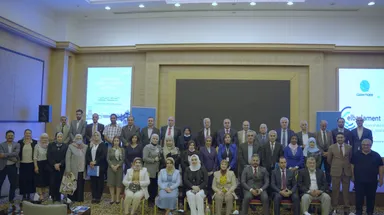 A large group of people pose indoors in front of screens reading "Water for Future" and "Clean Tigris" and an "elbarlament" banner.