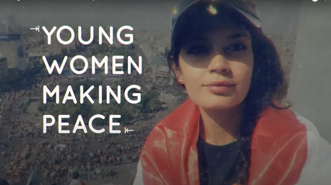 A woman wearing a cap and an orange scarf beside the text "YOUNG WOMEN MAKING PEACE" over an aerial photo of a crowded city square.