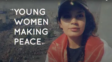 A woman wearing a cap and an orange scarf beside the text "YOUNG WOMEN MAKING PEACE" over an aerial photo of a crowded city square.