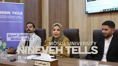A woman speaks into a microphone between two men at a panel event, with a banner reading "MOSUL TELLS" and overlaid text "MOSUL UNIVERSITY NINEVEH TELLS 2024".