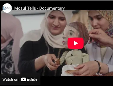 Video thumbnail reading "Mosul Tells - Documentary" showing two women in headscarves crafting a doll with a painted face, with a play button overlay.