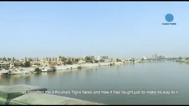 Video still of a city skyline along a river with a "Clean Tigris" logo and the subtitle "has forgotten the difficulties Tigris faces and how it has fought just to make its way to it".