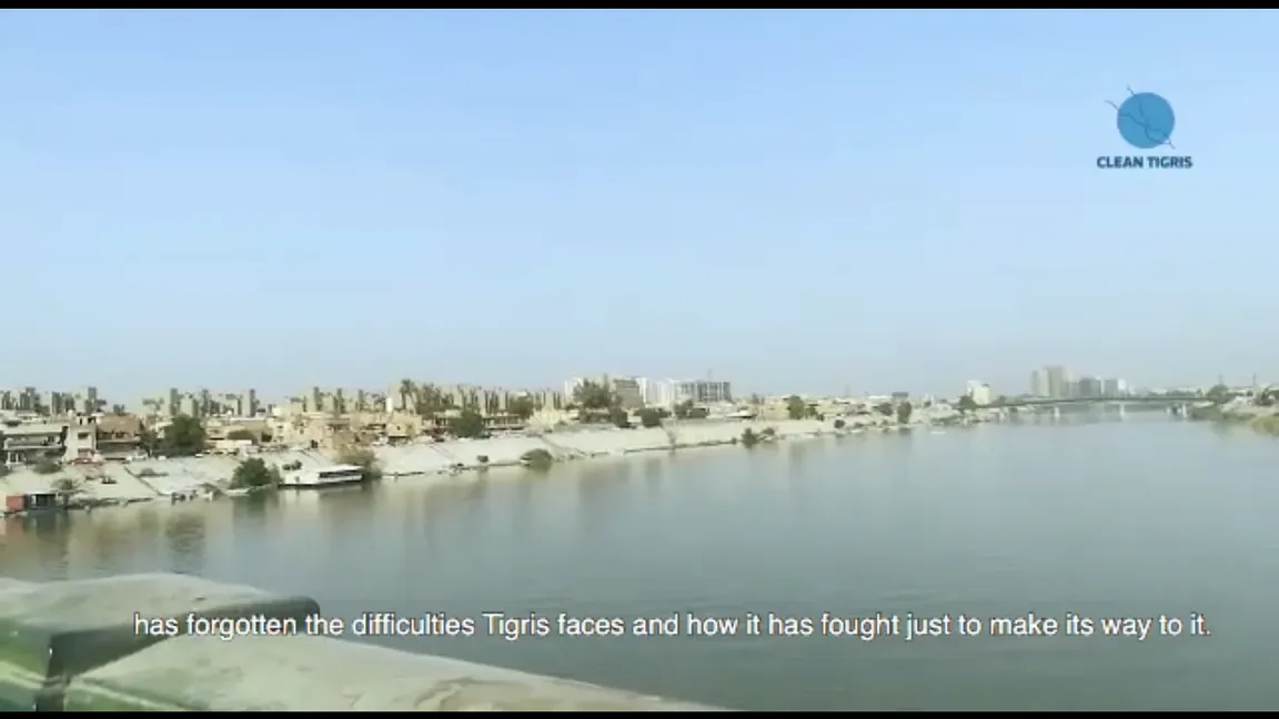 Video still of a city skyline along a river with a "Clean Tigris" logo and the subtitle "has forgotten the difficulties Tigris faces and how it has fought just to make its way to it".