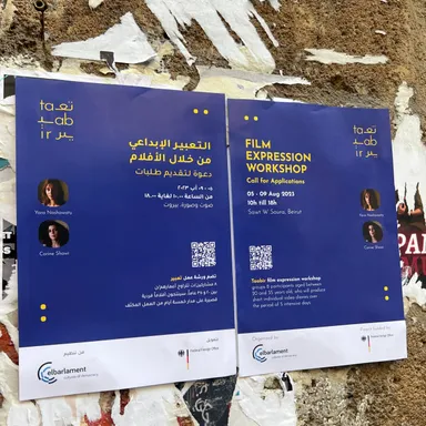 Two posters on a weathered wall, in Arabic and English, reading "Film Expression Workshop, Call for Applications, 05-09 Aug 2023, Sawt W Soura, Beirut" with photos captioned "Yara Nashawaty" and "Corine Shawi".