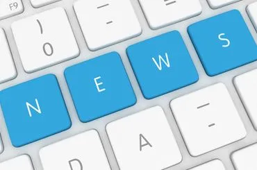 Close-up of computer keyboard keys highlighted in blue spelling "NEWS".