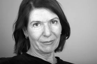 Black-and-white close-up portrait of a woman with shoulder-length hair, looking at the camera.